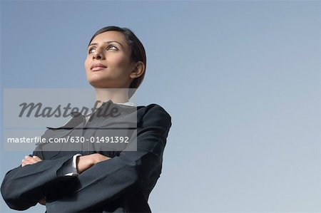 Low angle view of a businesswoman standing with her arms crossed