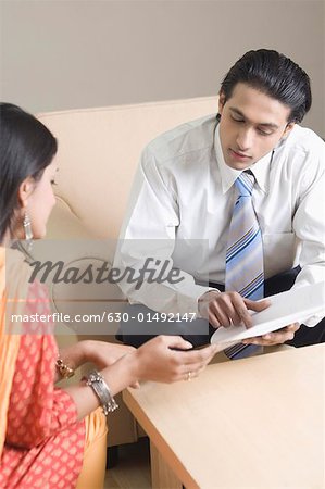 Real estate agent discussing a document with a young woman