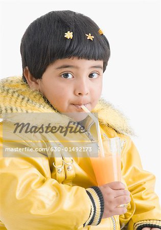 Portrait of a girl drinking juice with a straw