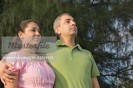 Close-up of a mid adult man standing with his arm around a mid adult woman