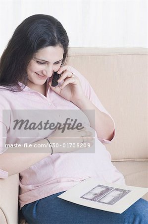 Close-up of a pregnant woman talking on a mobile phone