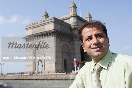 Close-up of a businessman smiling with monument in the background, Gateway  of India, Mumbai, Maharashtra, India - Stock Photo - Masterfile - Premium  Royalty-Free, Code: 630-01708702