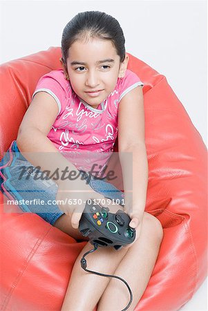 Close-up of a girl sitting on a bean bag and playing a video game