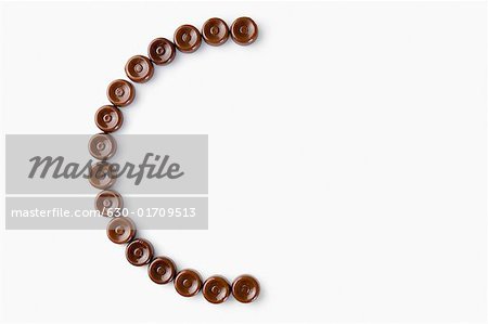 High angle view of brown candies arranged in the form of letter c