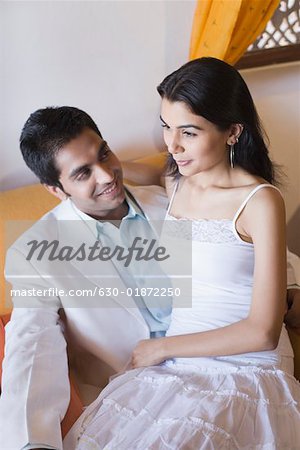Young woman sitting on the lap of a young man