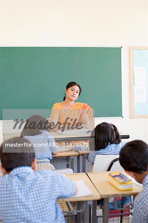 630 01873570em female teacher teaching her students in a classroom stock photo