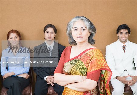 Portrait of a businesswoman standing in front of three business executives