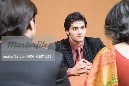 Businessman discussing with two business executives in a meeting