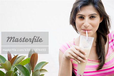 Сheerful african american young woman in summer dress and choker necklace  at cafe drinking milkshake cocktail Stock Photo - Alamy