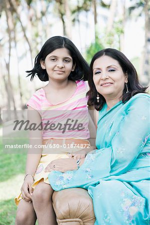 Portrait of a mature woman sitting on a couch with her daughter in a park