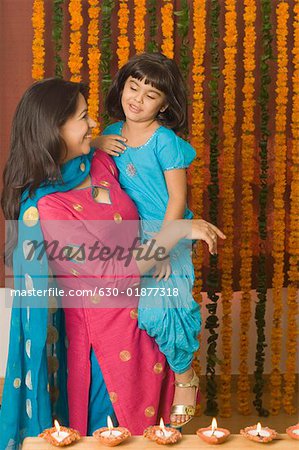 Young woman carrying her daughter and smiling