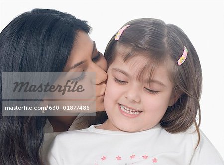 Close-up of a mid adult woman kissing her daughter