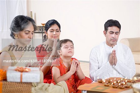 Family praying in front of figurines of God