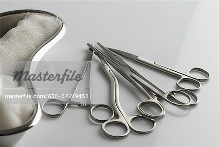 Close-up of surgical scissors and kidney dish