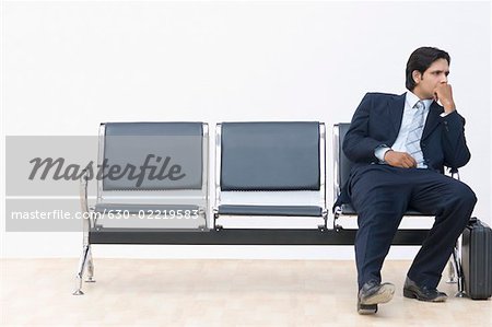 Businessman sitting on a bench and looking away