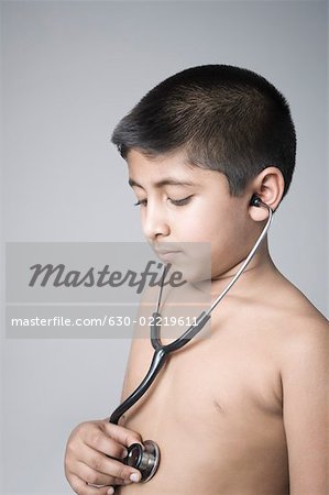 Close-up of a boy checking his heart rate with a stethoscope