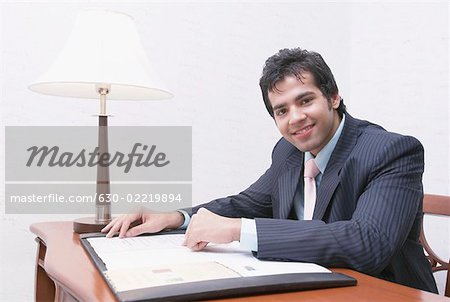 Portrait of a businessman reading a document and smiling