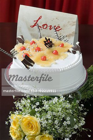 Close-up of a pineapple cake with a bunch of yellow roses