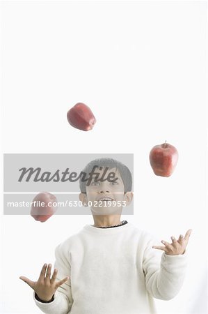 Boy juggling with apples
