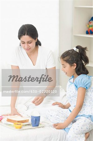 Mid adult woman having breakfast with her daughter