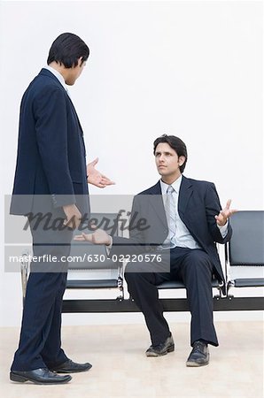 Two businessmen talking to each other and gesturing
