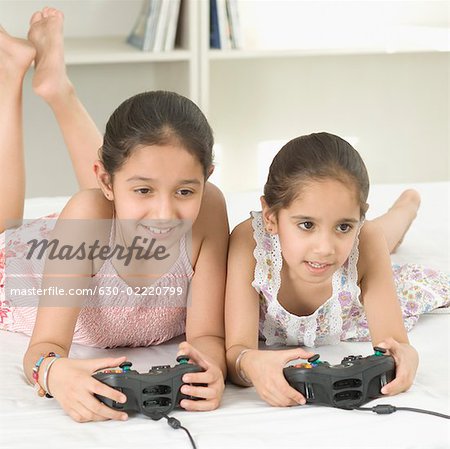 Children playing video game in bed - a Royalty Free Stock Photo