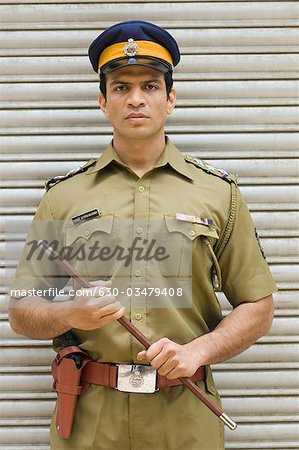 Portrait of a policeman holding a nightstick