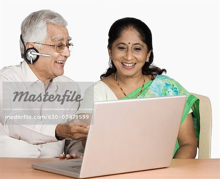 Senior man and a mature woman chatting online on a laptop