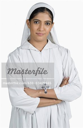 Portrait of a nun standing with her arms crossed