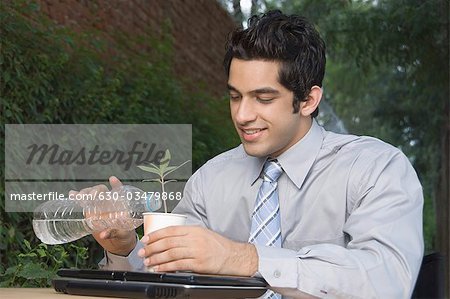 Businessman watering a plant