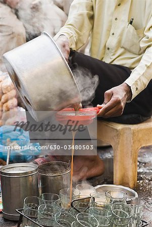 Man sieving tea into glasses, Delhi, India