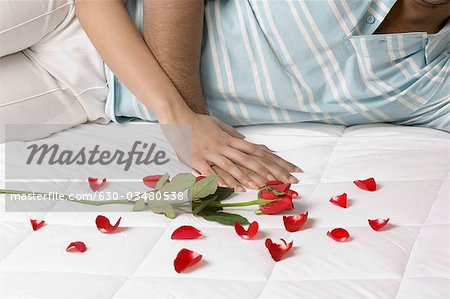 Couple lying on the bed with rose petals