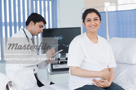 Female patient smiling with a male doctor writing a prescription
