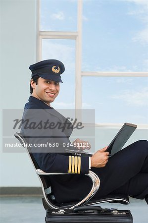 Pilot using a laptop at an airport