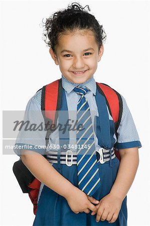 Portrait of a schoolgirl carrying a schoolbag and smiling