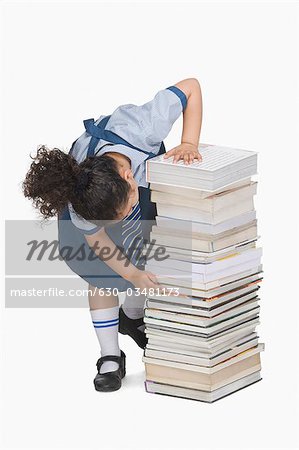Schoolgirl counting books in a stack