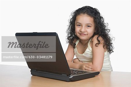 Portrait of a girl smiling in front of a laptop