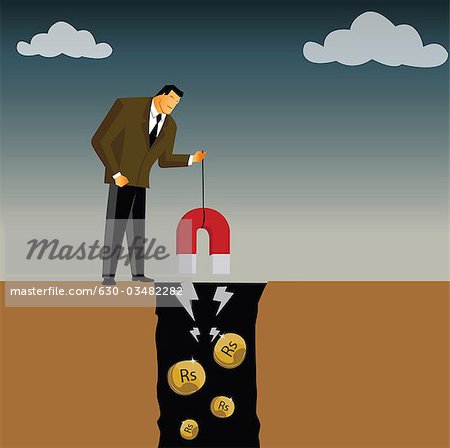 Businessman extracting money from a mine using a magnet