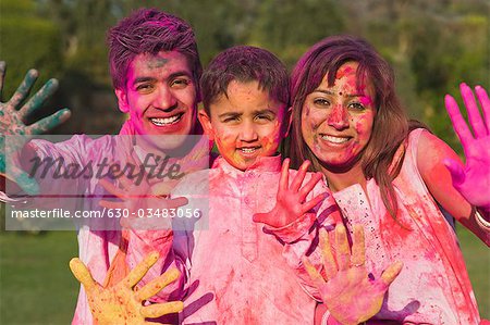 Family showing colorful hands on Holi