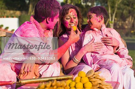 Family celebrating Holi with traditional Indian cuisines