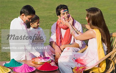 Family celebrating Holi in a garden