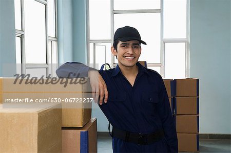 Delivery man with cardboard boxes in a warehouse