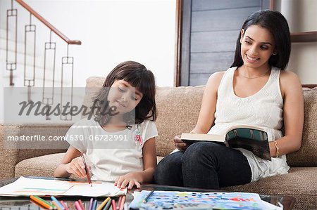 Woman looking at her daughter drawing