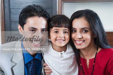 Portrait of a couple smiling with their daughter