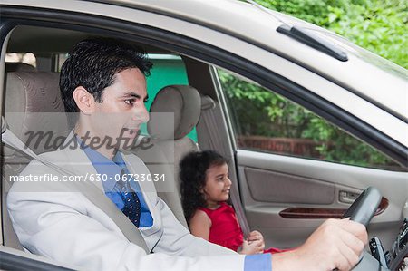 Businessman driving a car with his daughter