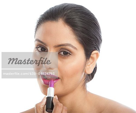 Woman applying pink lipstick