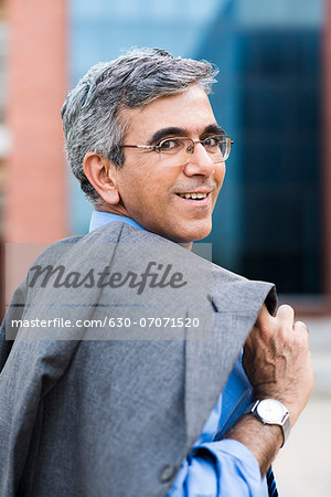 Businessman carrying his coat on shoulder