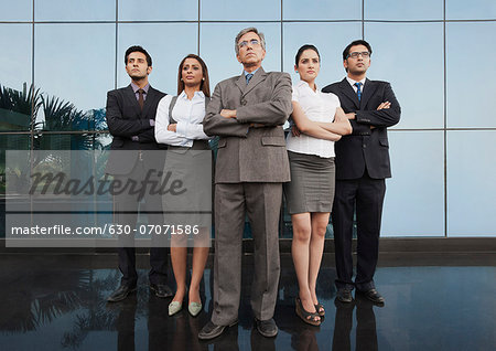 Business people standing together with their arms crossed - Stock