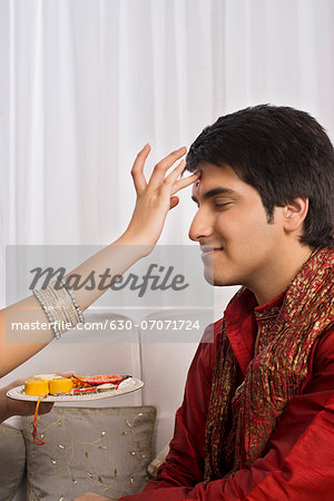 Sister applying tilak to her brother at Raksha Bandhan