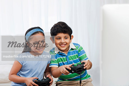 Children playing video game in bed - a Royalty Free Stock Photo